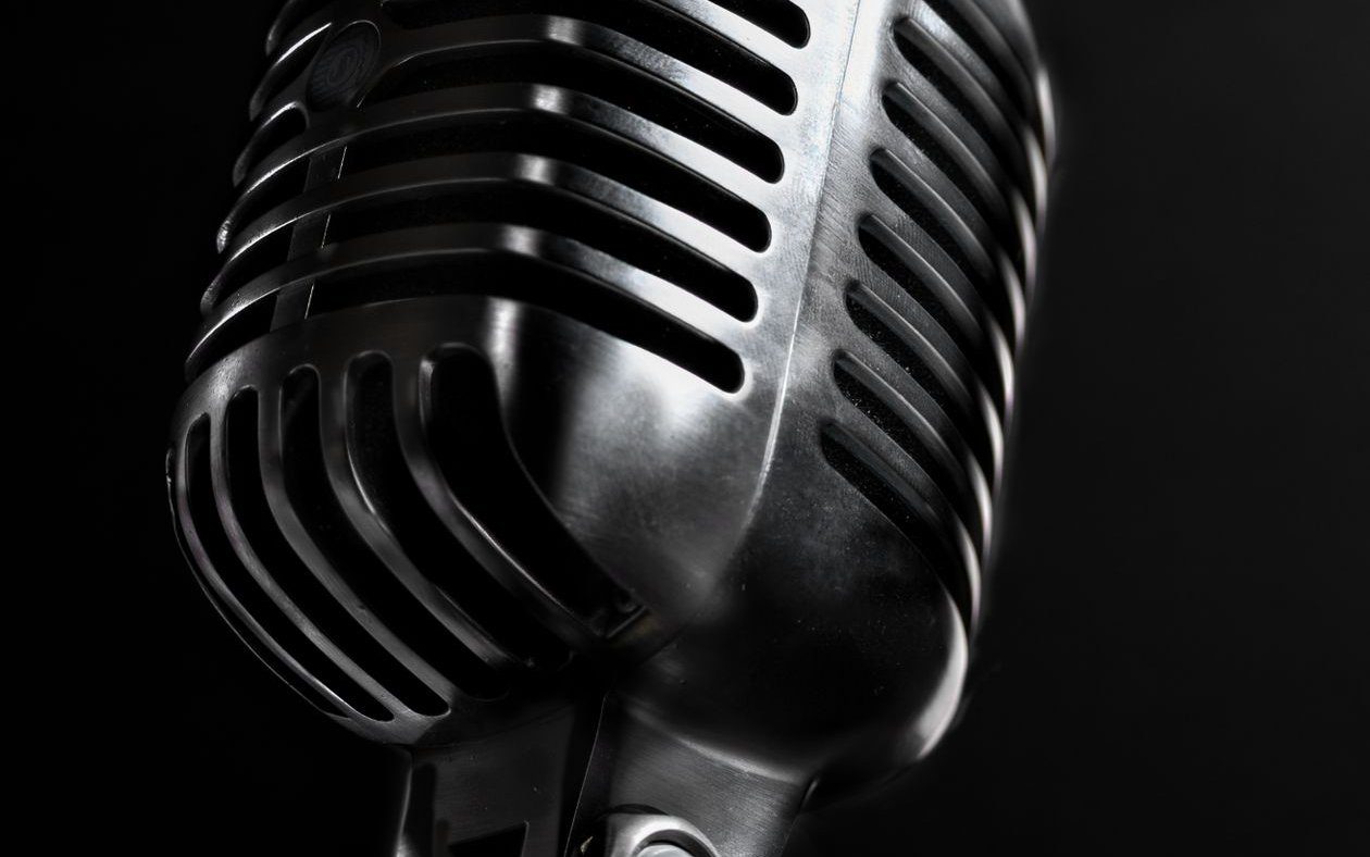 Vintage chrome studio microphone on black — Shark Bite Biz podcast